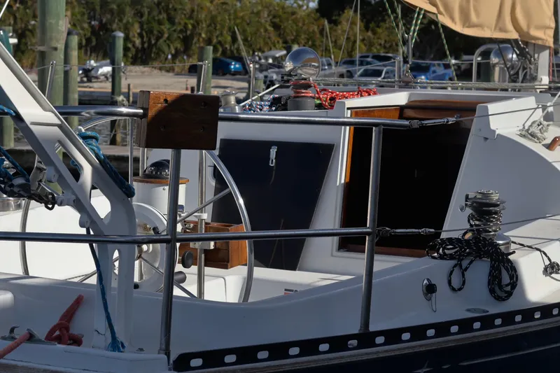 Slide: The Image of 1980 C&C Landfall 38 sailboat cockpit with steering wheel and ropes. - 11
