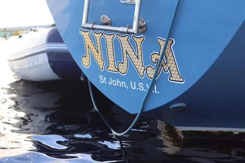 Slide: The Image of Blue C&C Landfall 38 sailboat stern with "Nina" and "St John, U.S.V.I." text. - 13