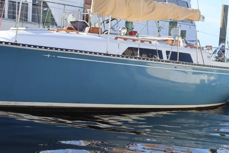 Slide: The Image of 1980 C&C Landfall 38 sailboat with blue hull docked in marina. - 17