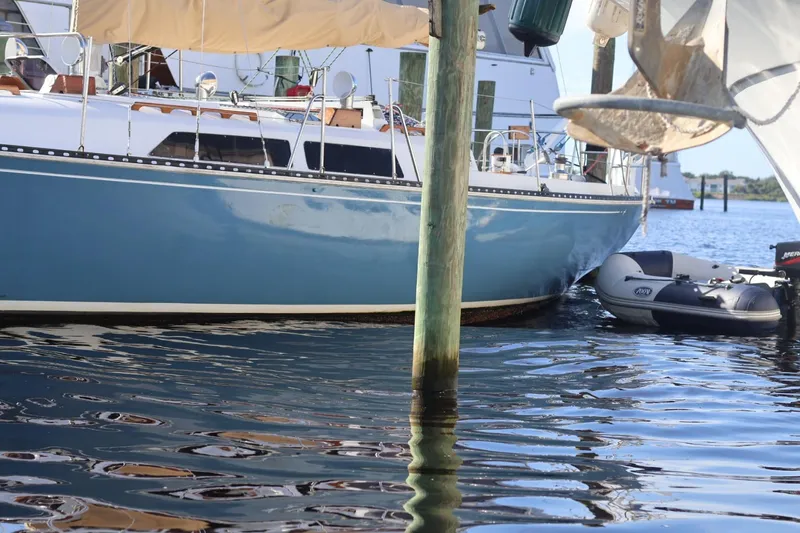 Slide: The Image of 1980 C&C Landfall 38 sailboat docked with inflatable dinghy on calm water. - 18