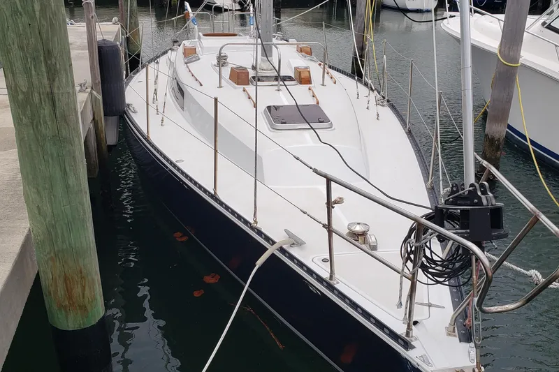 Slide: The Image of 1980 C&C Landfall 38 sailboat docked in marina, showcasing sleek design and classic features. - 2