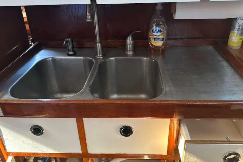 Slide: The Image of Galley sink area in 1980 C&C Landfall 38 sailboat with dual basins and wooden cabinetry. - 29