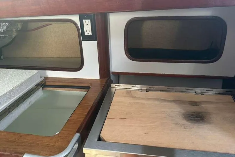 Slide: The Image of Interior of a 1980 C&C Landfall 38 sailboat, featuring wooden cabinetry and storage compartments. - 35