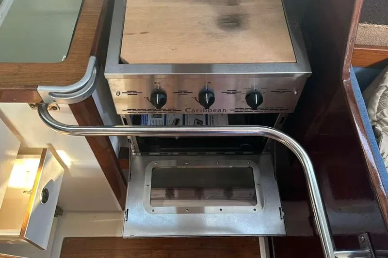 Slide: The Image of 1980 C&C Landfall 38 yacht kitchen with stainless steel stove and wooden countertop. - 38