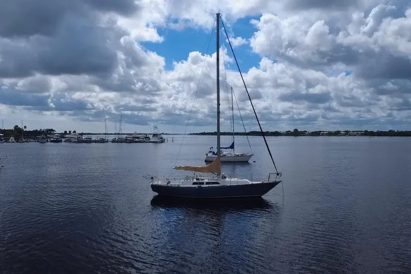 Slide: The Image of 1980 C&C Landfall 38 sailboat anchored on a calm, cloudy day. - 40