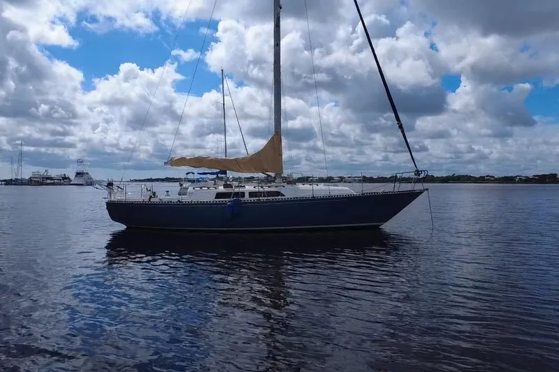 Slide: The Image of Sailboat on calm water, C&C Landfall 38, 1980 model, under a cloudy sky. - 42