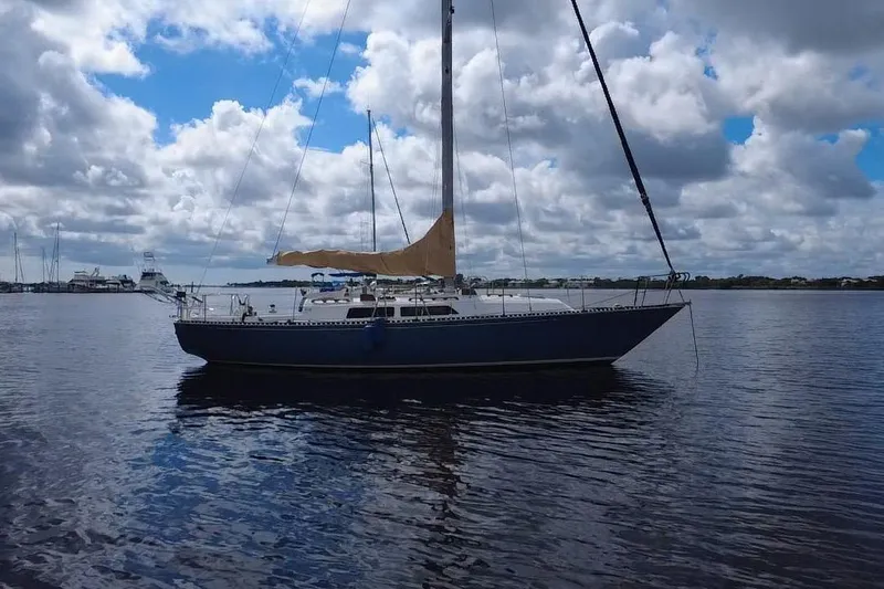 Slide: The Image of 1980 C&C Landfall 38 sailboat on calm water under cloudy sky. - 43