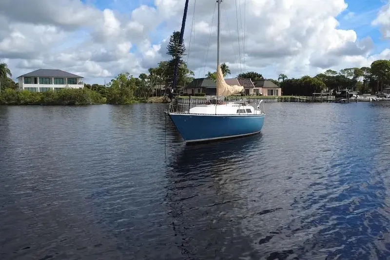 Slide: The Image of 1980 C&C Landfall 38 sailboat on calm water with houses in the background. - 44