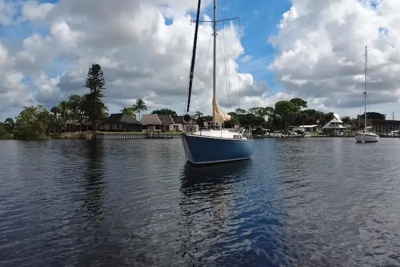 Slide: The Image of 1980 C&C Landfall 38 sailboat on calm water under a partly cloudy sky. - 46