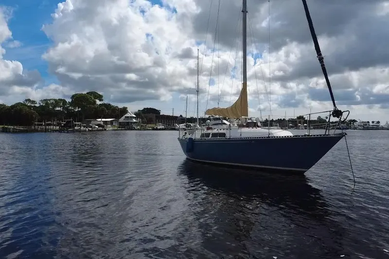 Slide: The Image of 1980 C&C Landfall 38 sailboat on calm water under cloudy sky. - 47