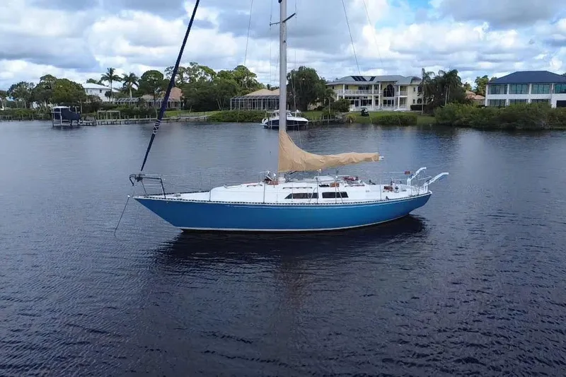 Slide: The Image of 1980 C&C Landfall 38 sailboat on calm water, with residential backdrop. - 53