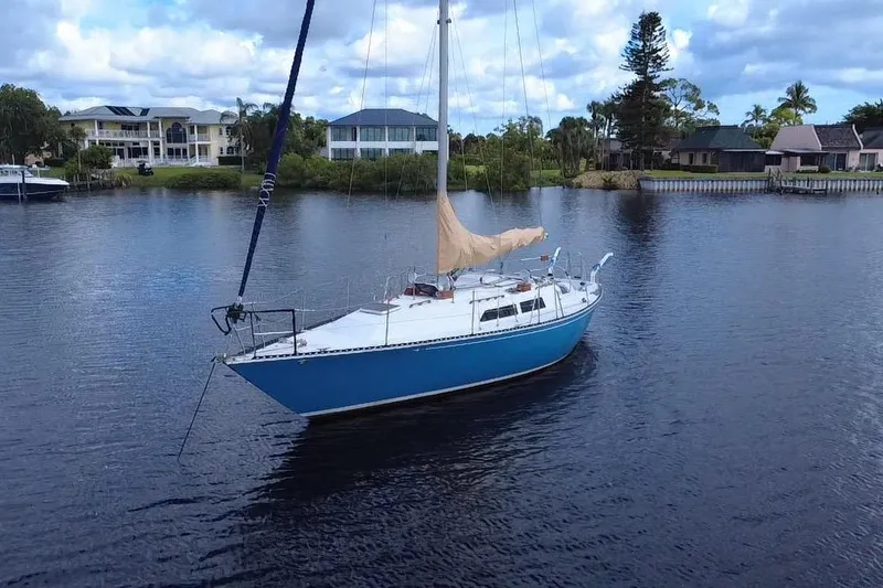 Slide: The Image of 1980 C&C Landfall 38 sailboat on calm water, surrounded by waterfront homes. - 54