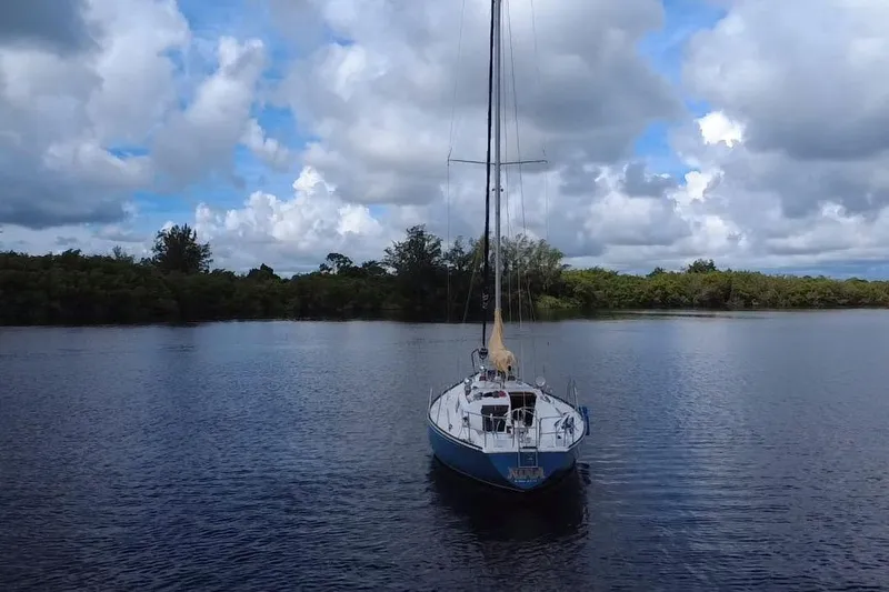 Slide: The Image of 1980 C&C Landfall 38 sailboat on calm water under cloudy sky. - 60