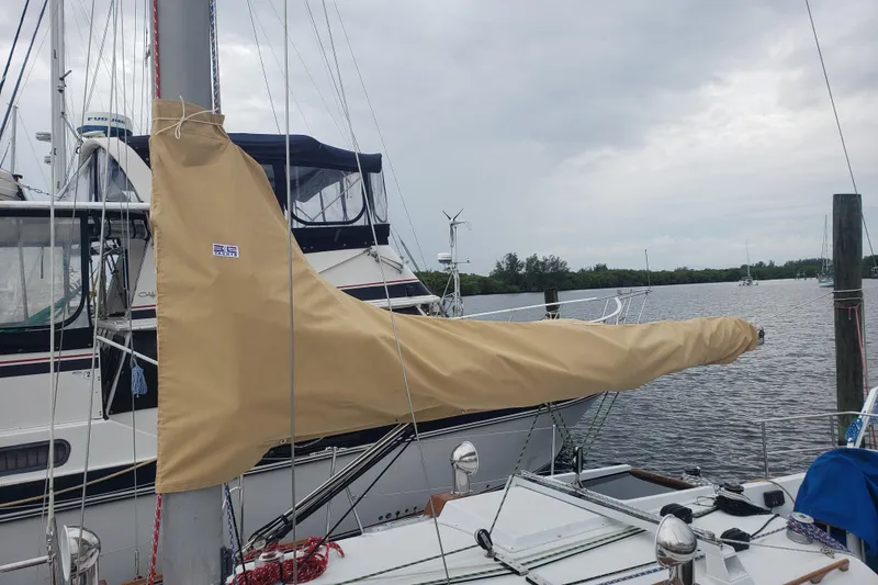 Slide: The Image of 1980 C&C Landfall 38 sailboat with tan sail cover docked by the water. - 7