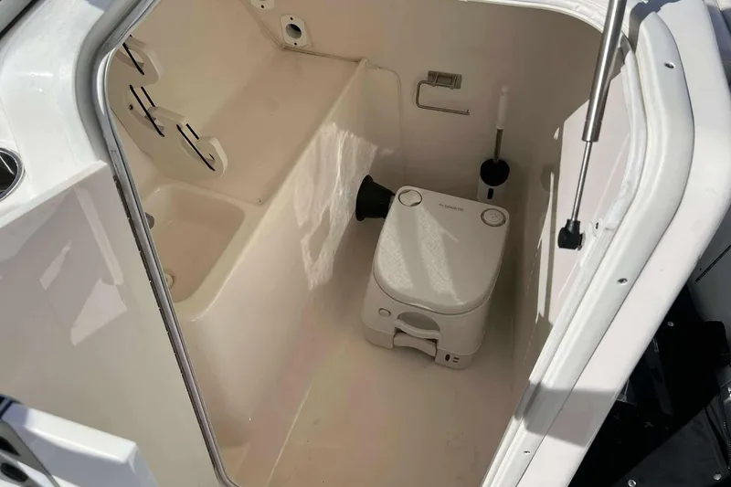 Slide: The Image of 2020 Key West 239 DFS boat interior with portable toilet and storage area. - 12