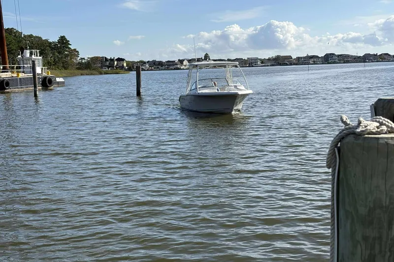 Slide: The Image of 2020 Key West 239 DFS boat on calm water near a dock, under a clear sky. - 13
