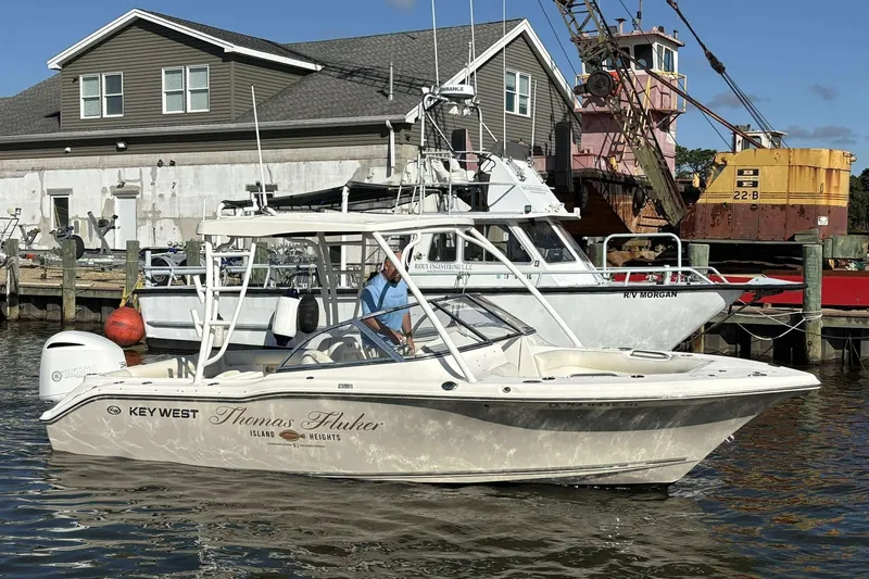 Slide: The Image of 2020 Key West 239 DFS boat docked near industrial waterfront, featuring "Thomas Fluker" name. - 15