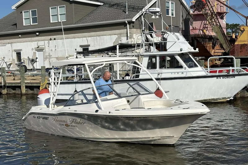 Slide: The Image of 2020 Key West 239 DFS boat docked near a marina, with a person onboard. - 18