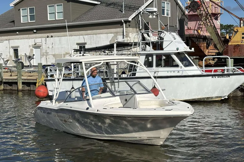 Slide: The Image of 2020 Key West 239 DFS boat navigating a marina, docked vessels in the background. - 19