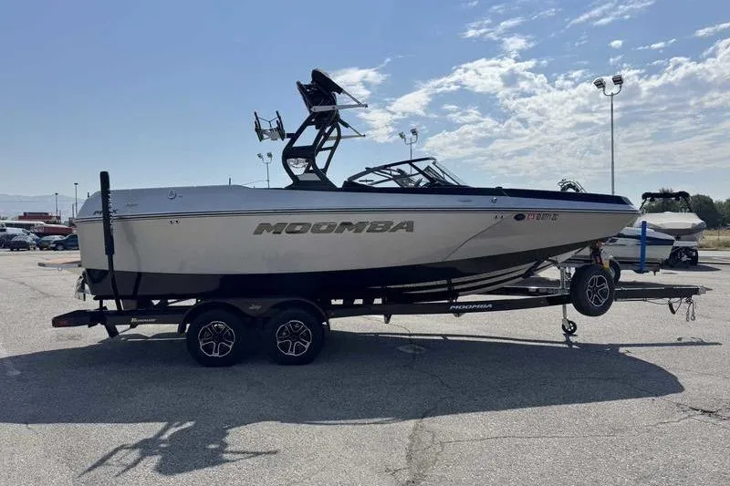 Slide: The Image of 2023 Moomba Max boat on trailer in parking lot under clear sky. - 9