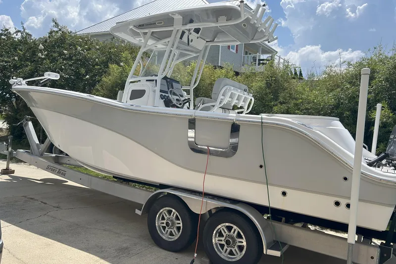 Slide: The Image of 2021 Sea Fox 268 Commander boat on trailer, parked outdoors under a cloudy sky. - 2