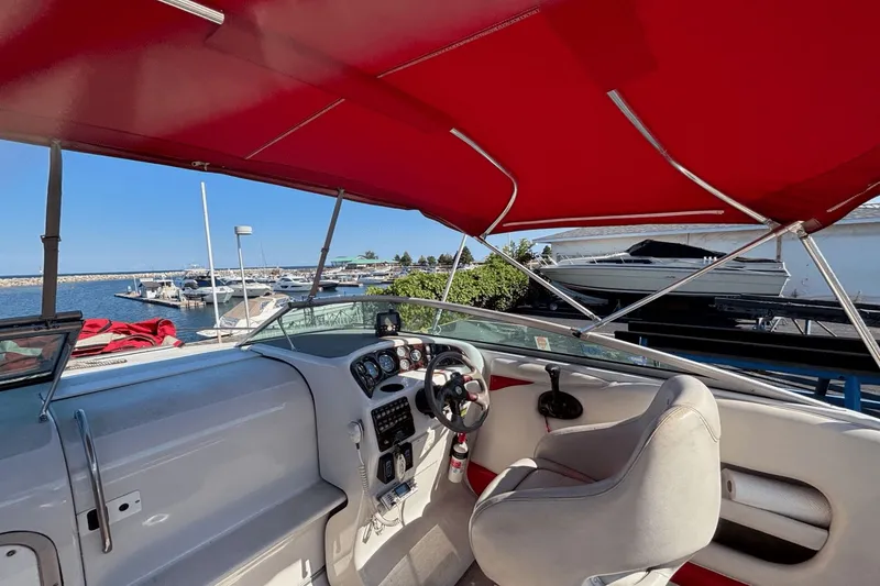 Slide: The Image of 2002 Crownline 215 CCR boat interior with red canopy, docked at marina. - 5