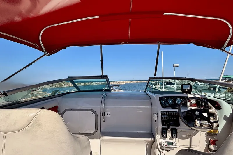 Slide: The Image of Interior view of a 2002 Crownline 215 CCR boat with red canopy and steering controls. - 6