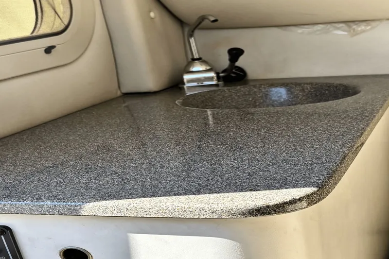 Slide: The Image of 2002 Crownline 215 CCR boat interior with sleek countertop and sink. - 8