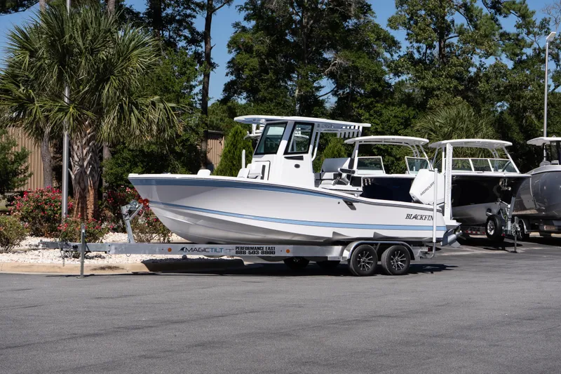 The Image of 2026 Blackfin 242 HB boat on trailer, surrounded by trees and other boats. - 1