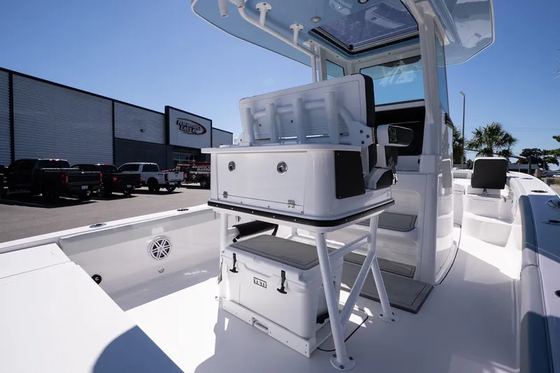 Slide: The Image of 2026 Blackfin 242 HB boat interior with seating and storage, parked outdoors. - 10