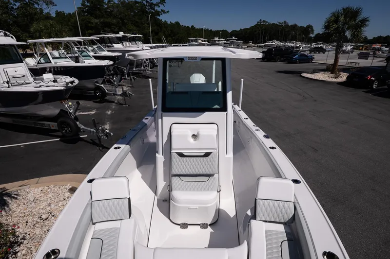 Slide: The Image of 2026 Blackfin 242 HB boat with sleek design, parked in a marina lot. - 24