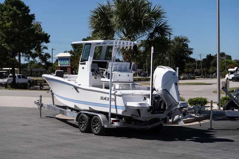 Slide: The Image of 2026 Blackfin 242 HB boat on trailer, parked outdoors under clear blue sky. - 5