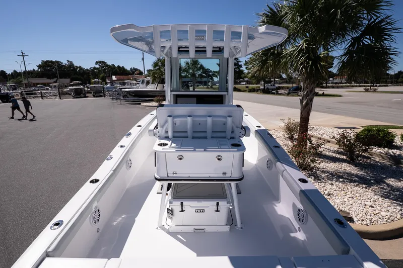 Slide: The Image of 2026 Blackfin 242 HB boat, sleek design, spacious deck, parked near palm trees. - 9