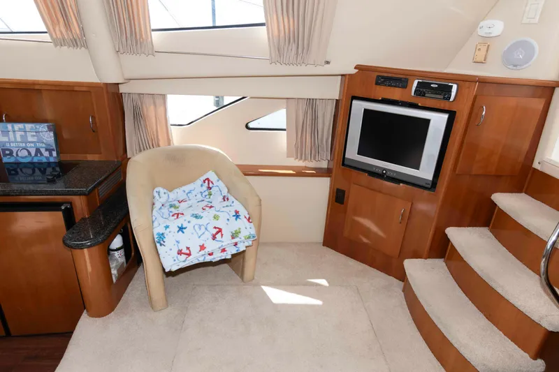 Slide: The Image of Interior of 2005 Carver 41 Cockpit Motor Yacht with TV, chair, and stairs. - 15
