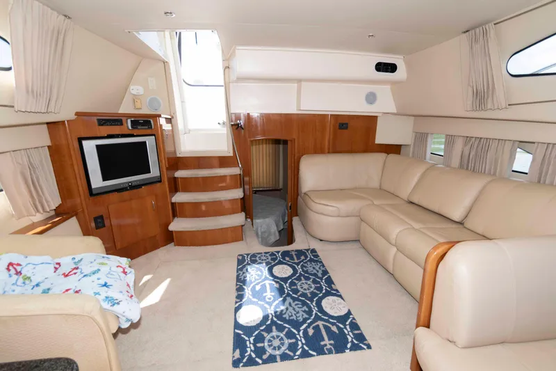 Slide: The Image of Luxurious interior of 2005 Carver 41 Cockpit Motor Yacht with beige seating and entertainment area. - 16