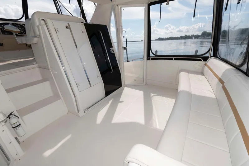 Slide: The Image of 2005 Carver 41 Cockpit Motor Yacht interior with white seating and panoramic windows. - 6