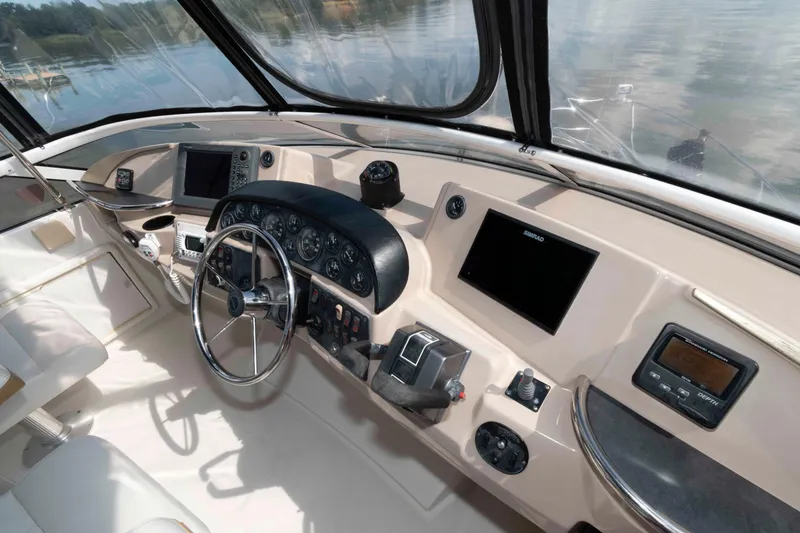 Slide: The Image of 2005 Carver 41 Cockpit Motor Yacht helm with modern navigation instruments and steering wheel. - 10