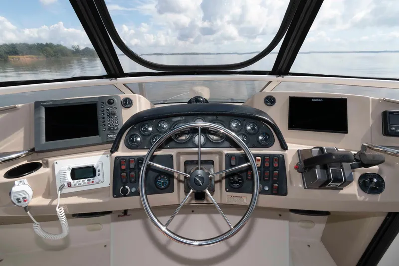 Slide: The Image of 2005 Carver 41 Cockpit Motor Yacht helm with steering wheel and navigation controls. - 11