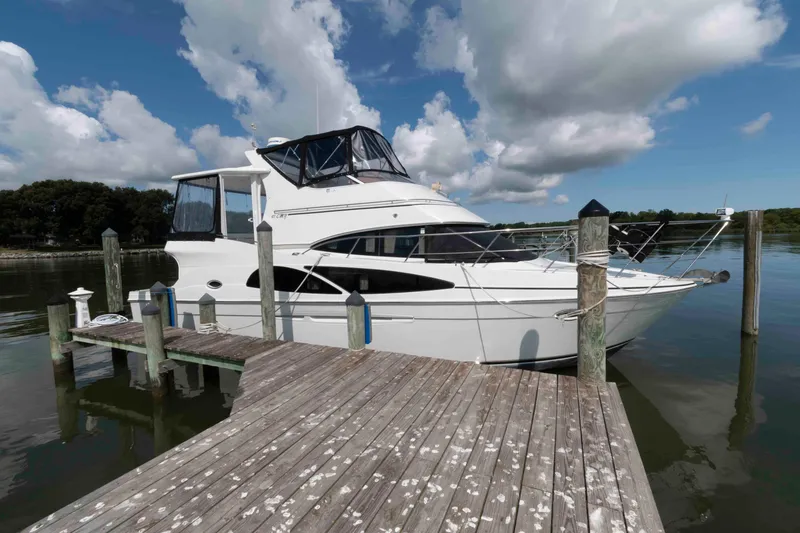 Slide: The Image of 2005 Carver 41 Cockpit Motor Yacht docked on a sunny day with cloudy sky. - 2