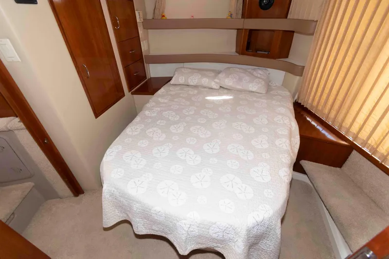 Slide: The Image of 2005 Carver 41 Cockpit Motor Yacht bedroom with cozy bed and wooden cabinetry. - 21
