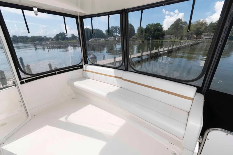 Slide: The Image of 2005 Carver 41 Cockpit Motor Yacht interior with white seating and scenic water view. - 7