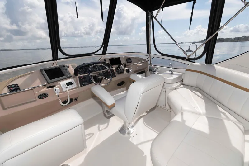 Slide: The Image of 2005 Carver 41 Cockpit Motor Yacht interior with white seating and navigation controls. - 8