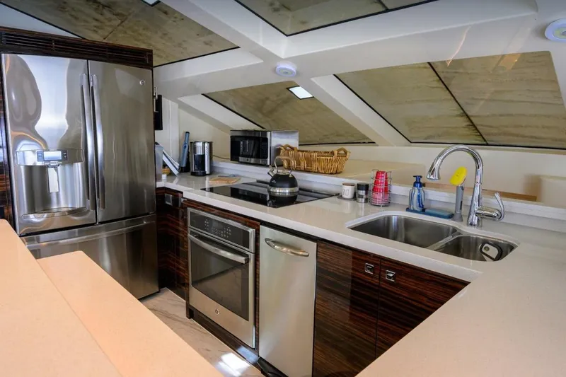 Slide: The Image of Luxurious yacht kitchen interior with modern appliances, featuring stainless steel fridge and sleek countertops. Hampton Fly 2014. - 13