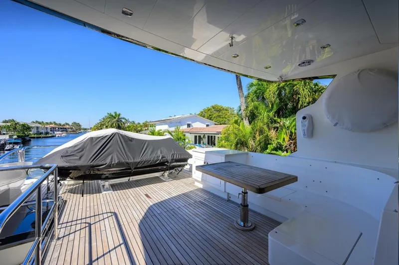 Slide: The Image of Luxury yacht deck with seating and table, Hampton Fly 2014 model, overlooking serene waterfront. - 38