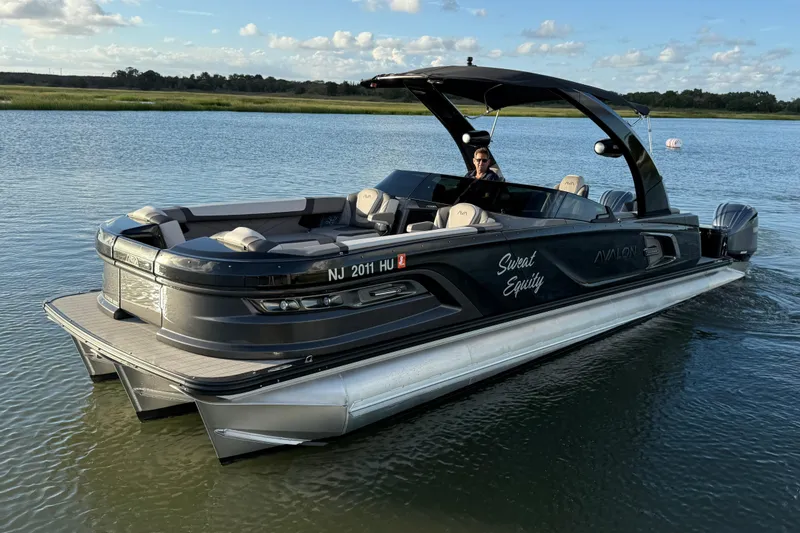 Slide: The Image of 2025 Avalon Excalibur Quad Lounge Windshield pontoon boat on serene water. - 12