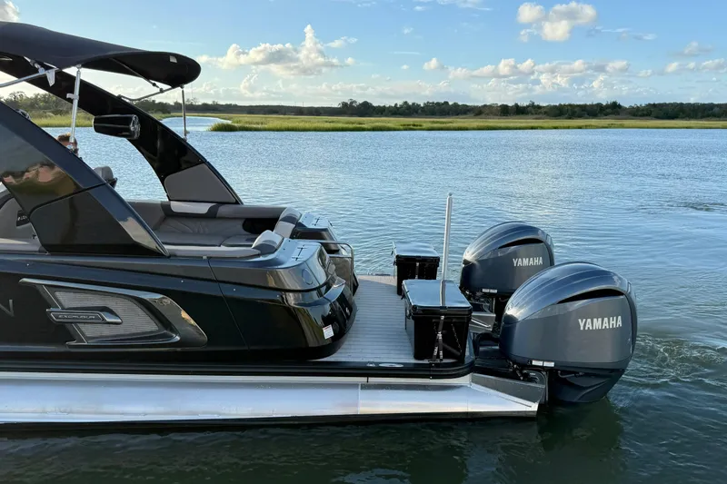 Slide: The Image of 2025 Avalon Excalibur Quad Lounge Windshield boat with Yamaha engines on a serene lake. - 14