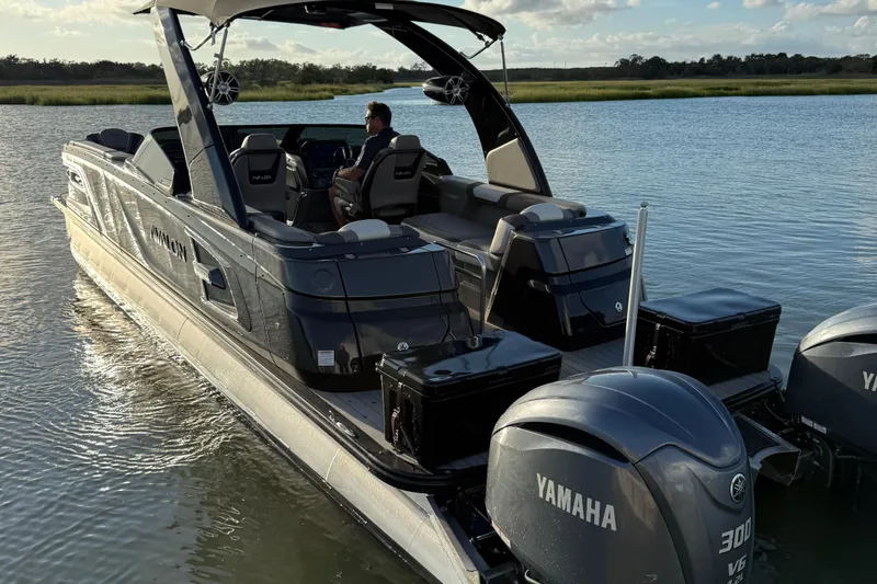 Slide: The Image of 2025 Avalon Excalibur Quad Lounge Windshield boat with Yamaha engines on a serene lake. - 16