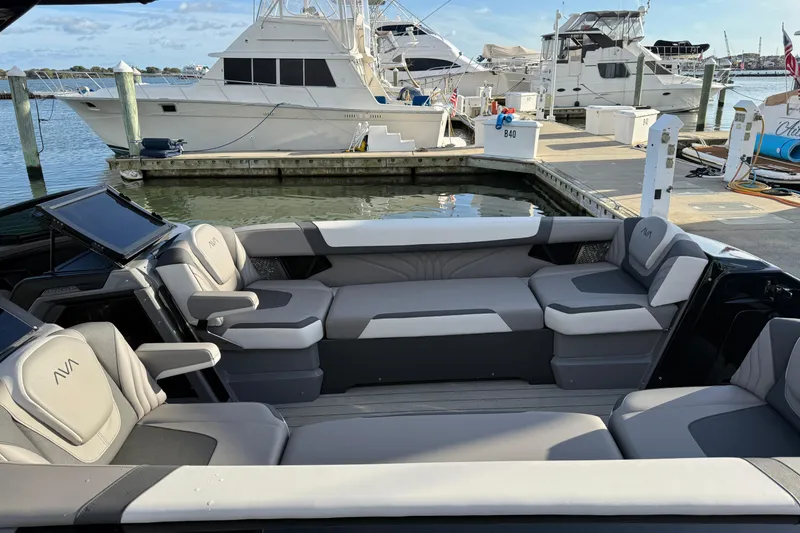 Slide: The Image of 2025 Avalon Excalibur Quad Lounge Windshield boat interior at marina, featuring luxurious seating. - 20