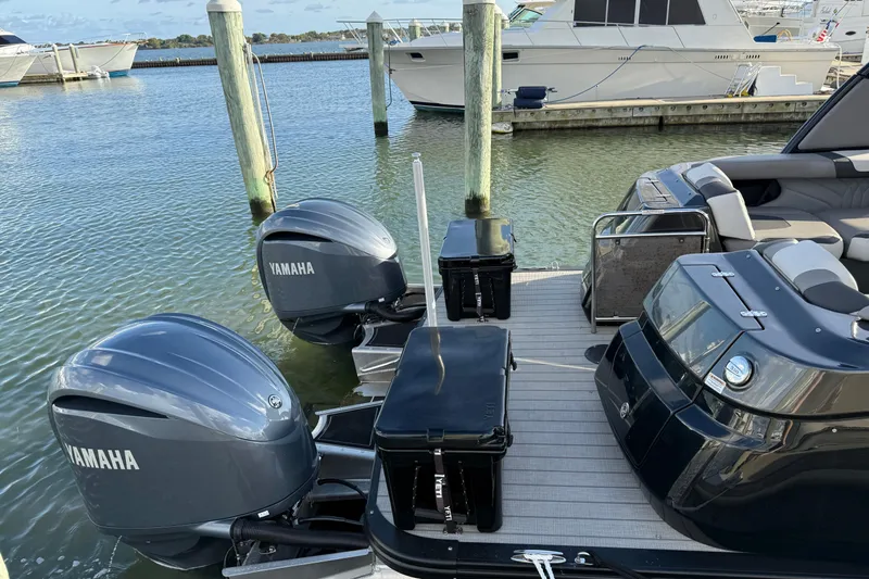 Slide: The Image of 2025 Avalon Excalibur Quad Lounge Windshield boat with Yamaha engines docked at marina. - 25