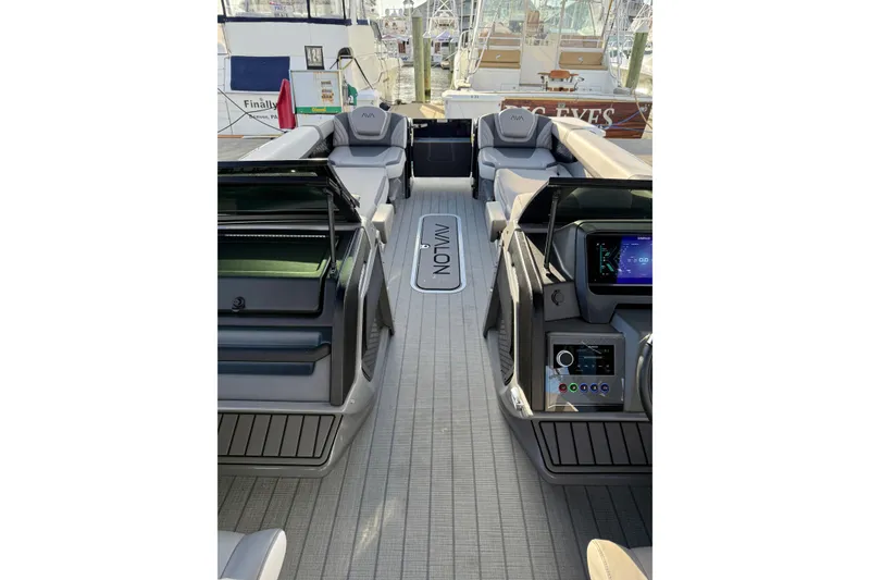 Slide: The Image of 2025 Avalon Excalibur Quad Lounge Windshield boat interior with modern dashboard and seating. - 33
